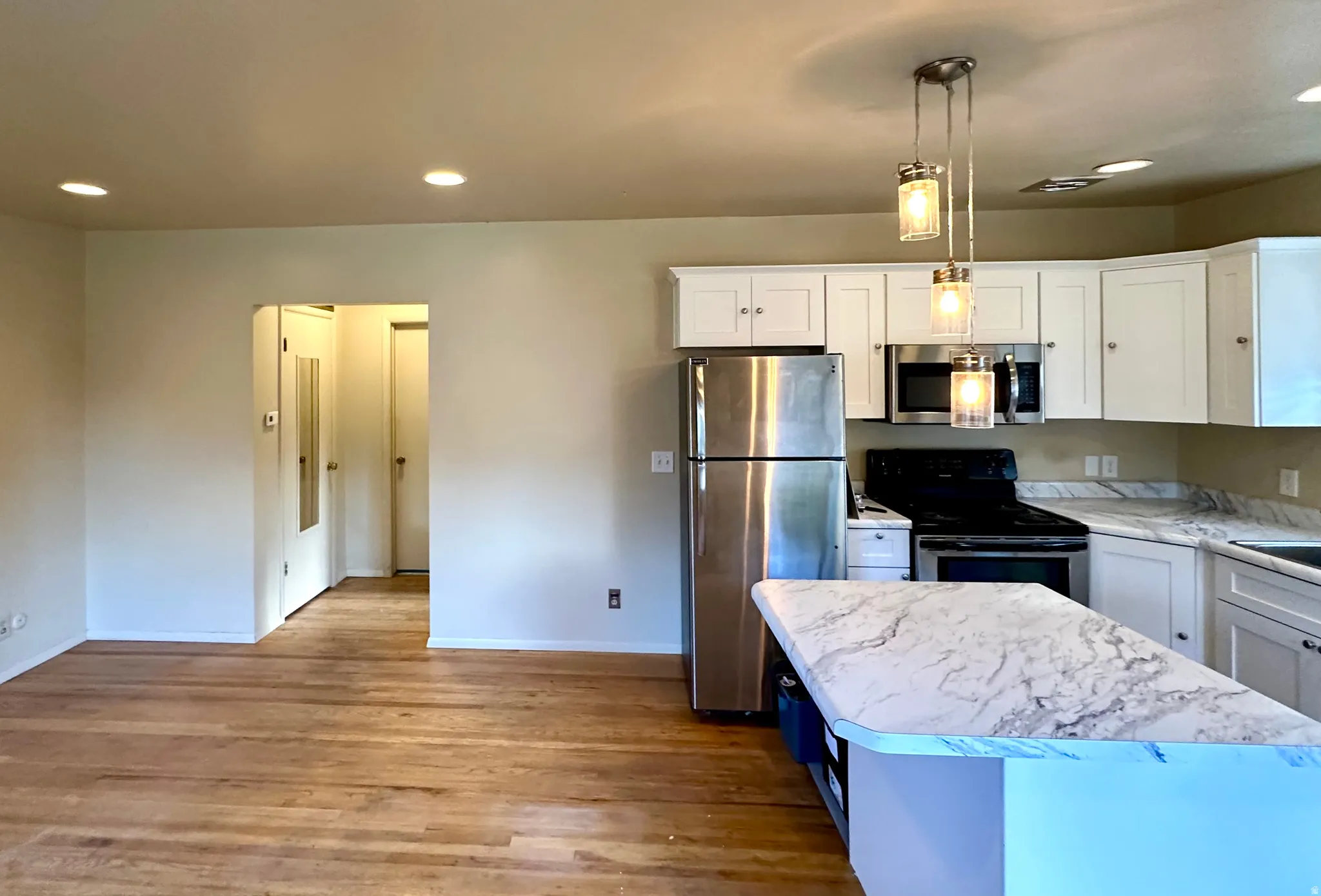 Kitchen featuring white cabinetry, stainless steel appliances, and light-toned countertops