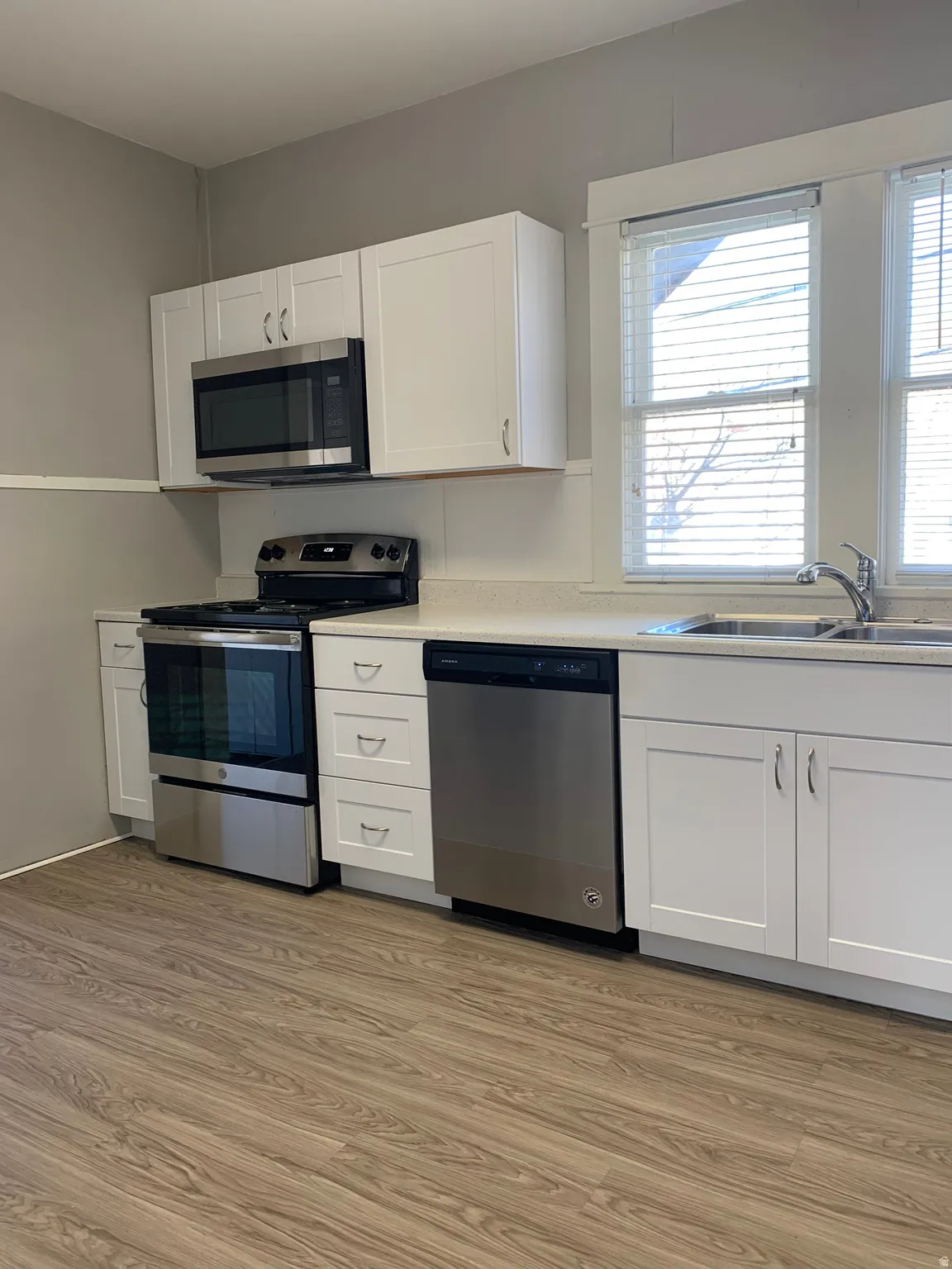 Modern kitchen featuring white shaker cabinetry and stainless steel appliances