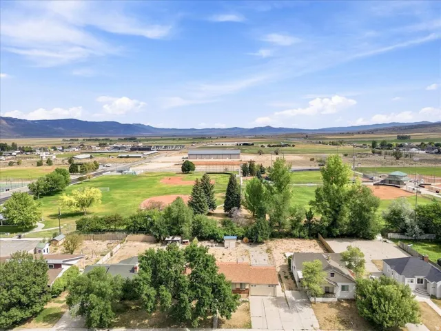 Expansive open fields and distant mountains frame this property