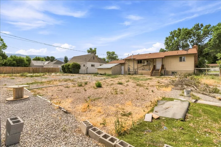 Expansive rear yard with a gravel base and natural landscaping