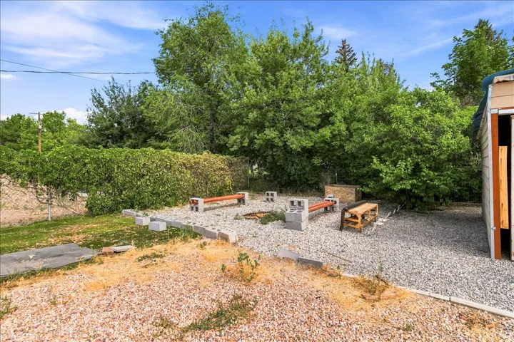 Outdoor entertaining area featuring a gravel surface, built-in benches, and a central fire pit area