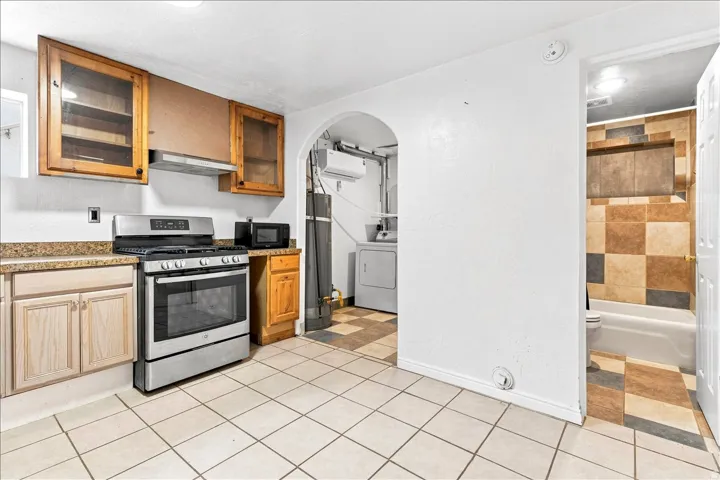 Kitchen area featuring a stainless steel gas range, stone-finish countertops, and wood cabinetry
