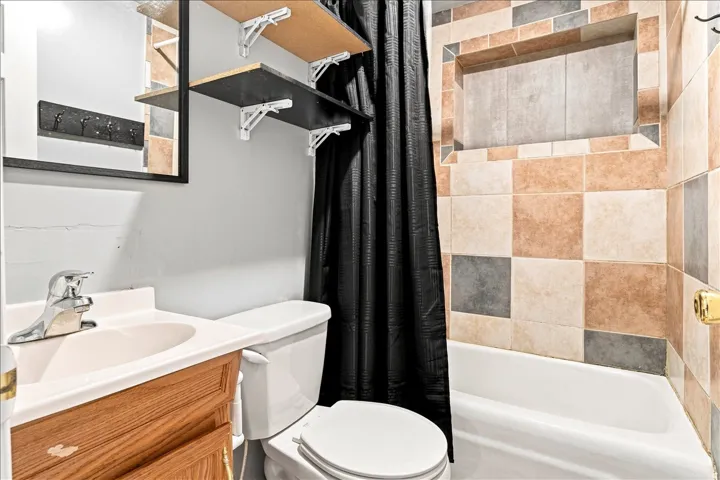 Bathroom featuring a vanity with a laminate countertop, a chrome faucet, and a wall-mounted mirror