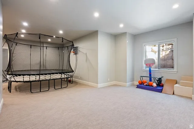 Spacious recreation room featuring recessed lighting, light gray wall paint, and neutral carpeting