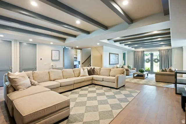 Spacious living area featuring wood-finish flooring, recessed lighting, and exposed ceiling beams