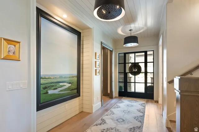 Entryway featuring a grid-paneled glass door with sidelights, wood-finish flooring, and shiplap ceiling