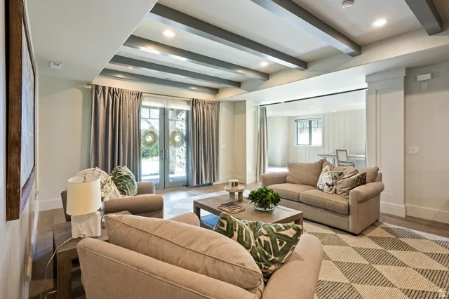 Spacious living area featuring exposed ceiling beams and recessed lighting