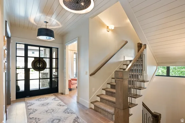 Entryway featuring a large grid-pattern glass door, wood-finish flooring, and shiplap ceiling