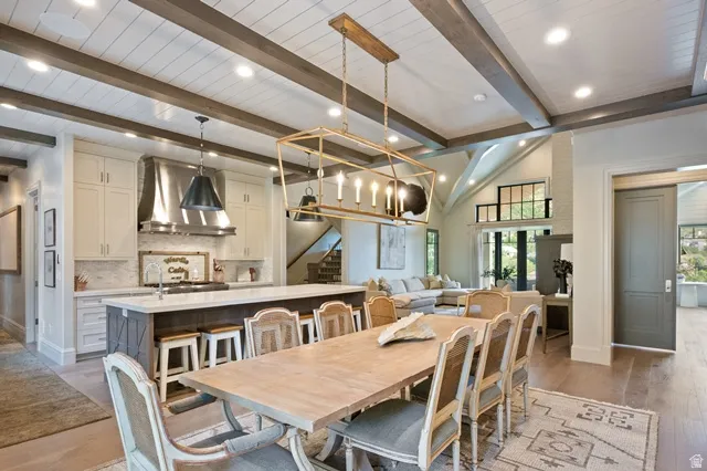 Dining area featuring a wood-finish table, upholstered chairs, and a geometric chandelier