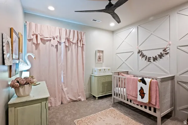 Recessed lighting illuminates a room featuring an accent wall with decorative paneling
