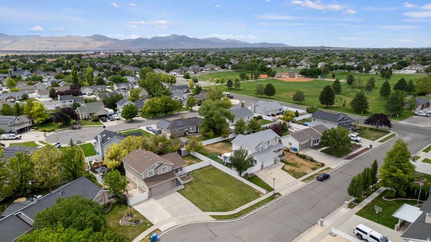 Aerial perspective showcasing a residential neighborhood with a prominent green space