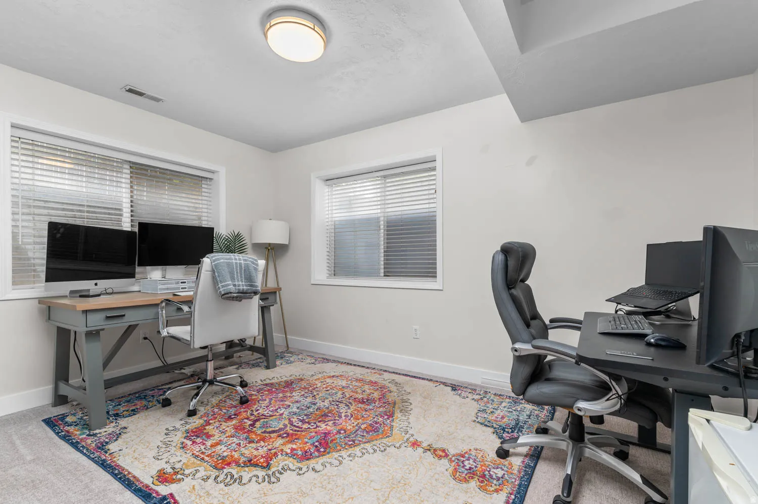 Bright room featuring light-toned walls and two windows with blinds