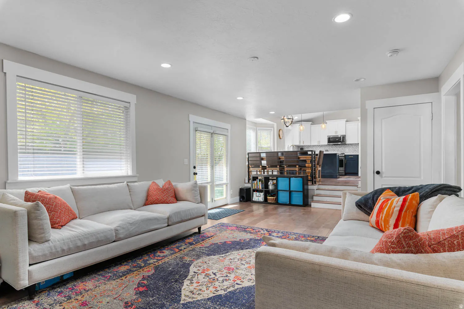 Open-concept living space featuring wood-finish flooring, recessed lighting, and white trim