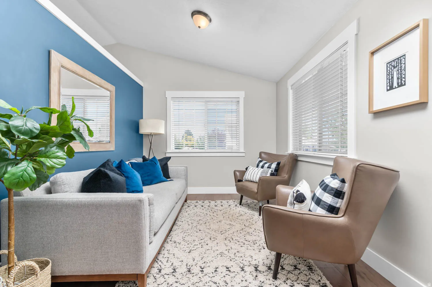 Living area featuring a vaulted ceiling and wood-finish flooring