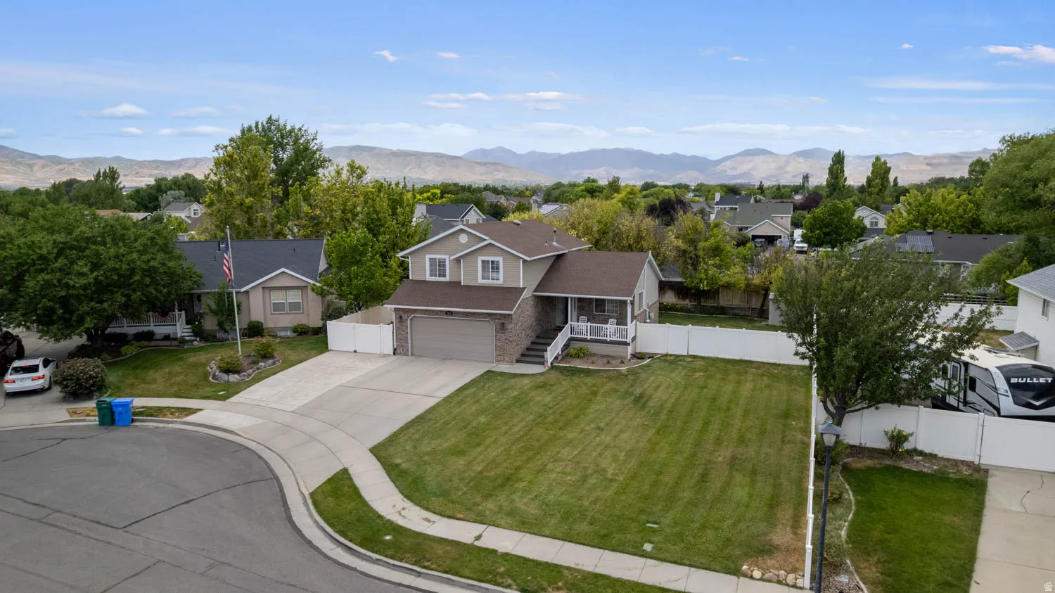 Two-story residence with a two-car garage, concrete driveway, and a front lawn
