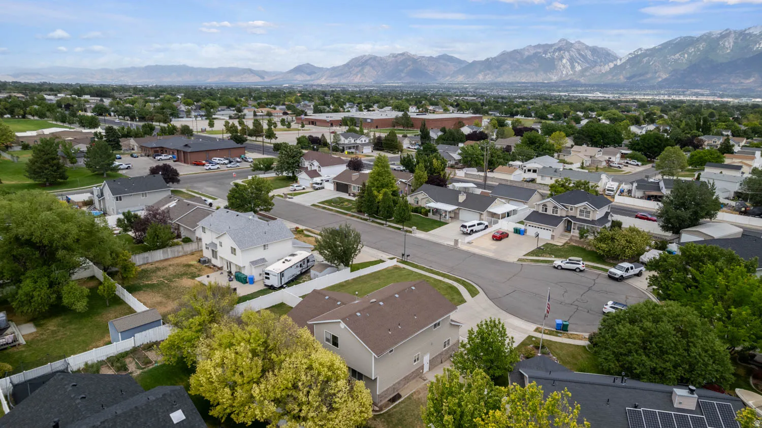 Residential neighborhood with mature trees and mountain scenery
