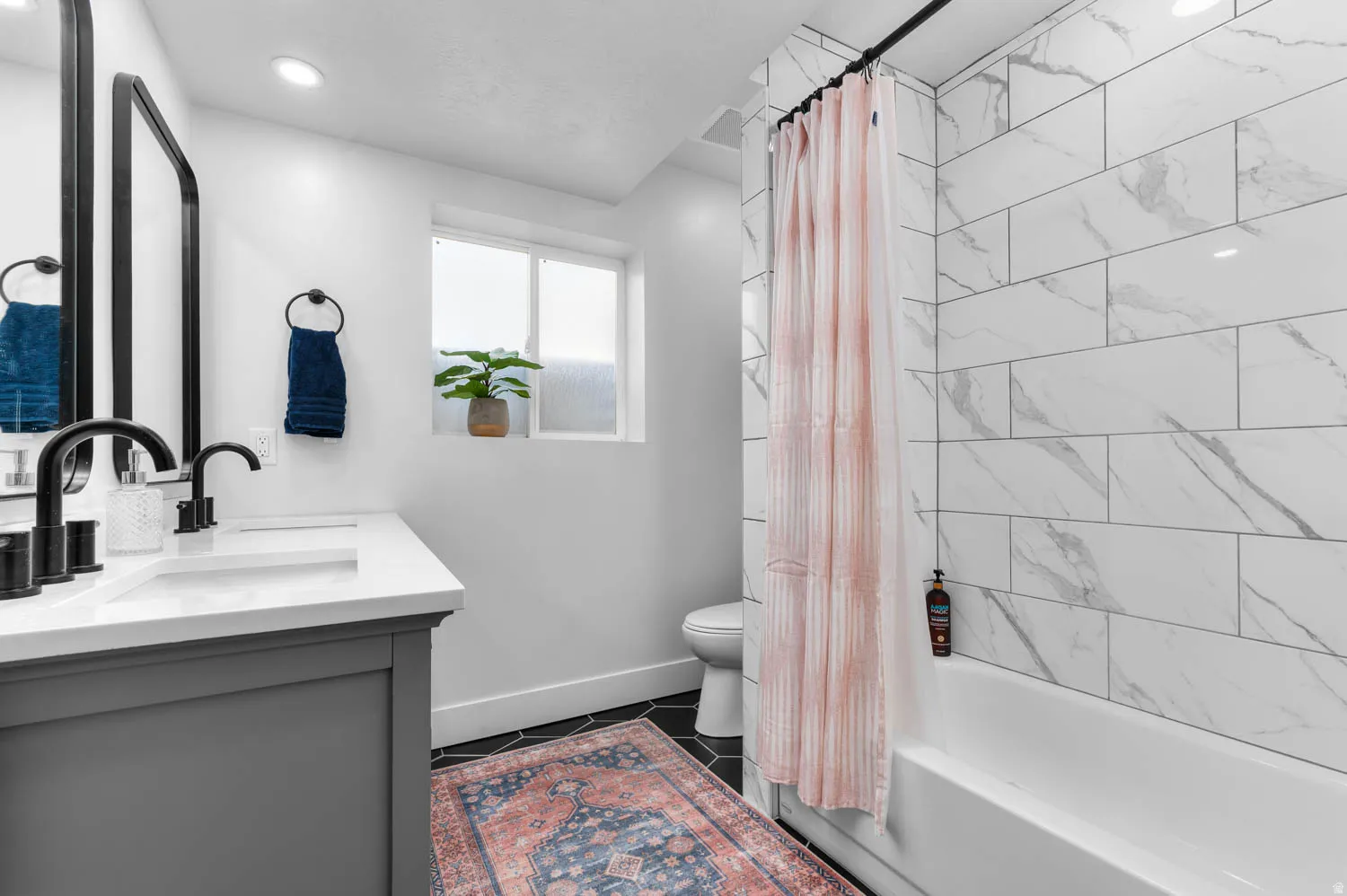Modern bathroom featuring a double vanity with matte black hardware and a white countertop