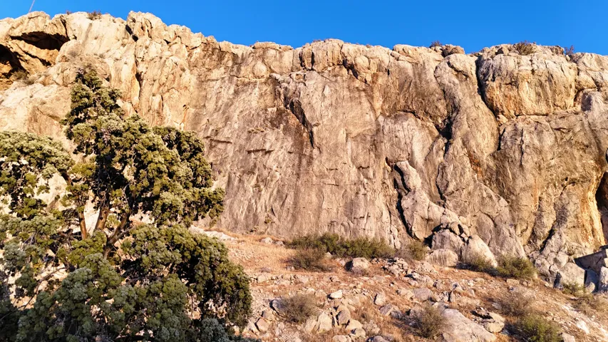 Natural rock formations and a desert landscape with mature shrubbery and sparse vegetation