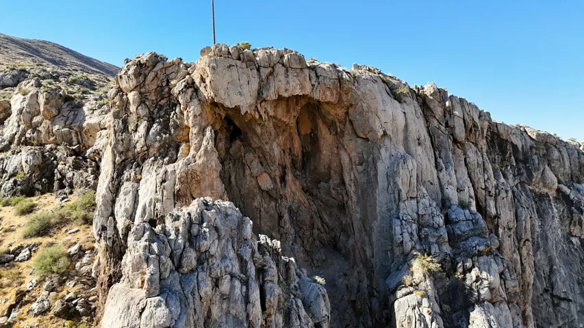 Natural rock formation featuring a prominent cavernous opening and rugged, textured surfaces