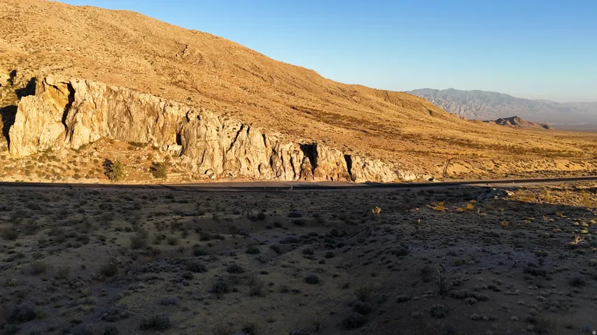 Expansive desert landscape featuring rugged mountain terrain and a clear sky