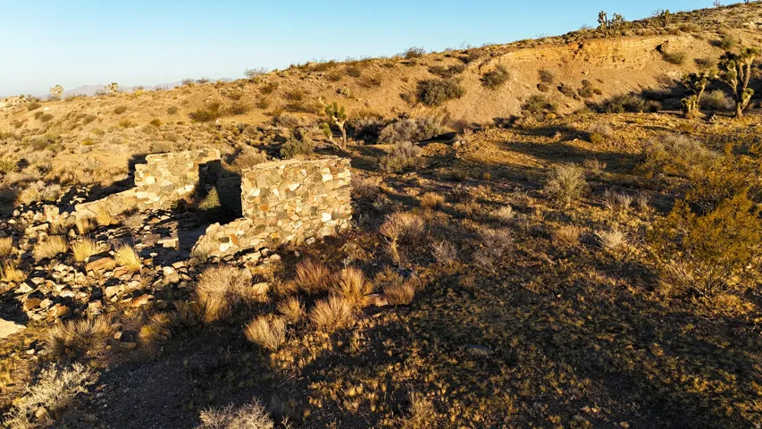 Stone wall remnants on a desert landscape with natural rock formations and native vegetation