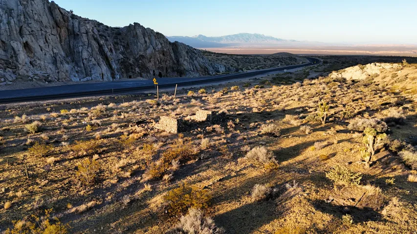 Expansive desert terrain featuring natural rock formations and a distant highway