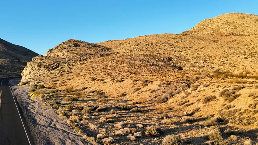 Expansive desert landscape with a paved road curving through the terrain