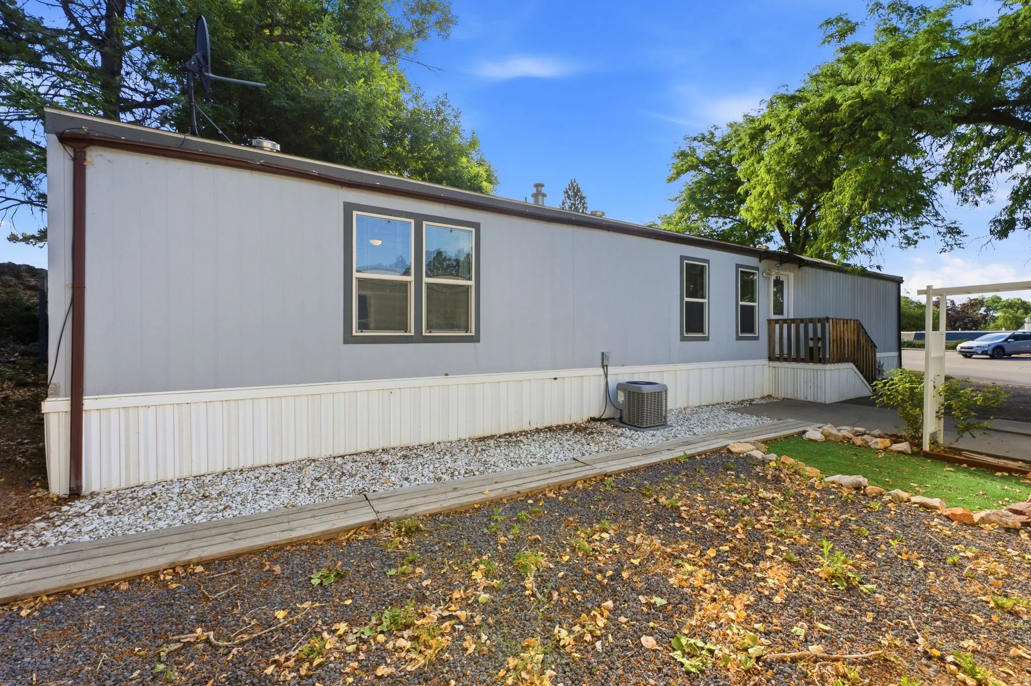 Light gray siding with white skirting and dark trim