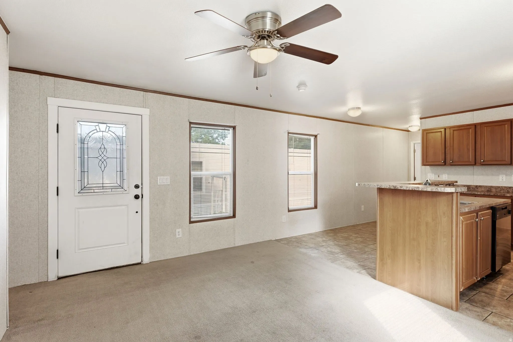 Entry area with a decorative glass front door, two windows, and a ceiling fan