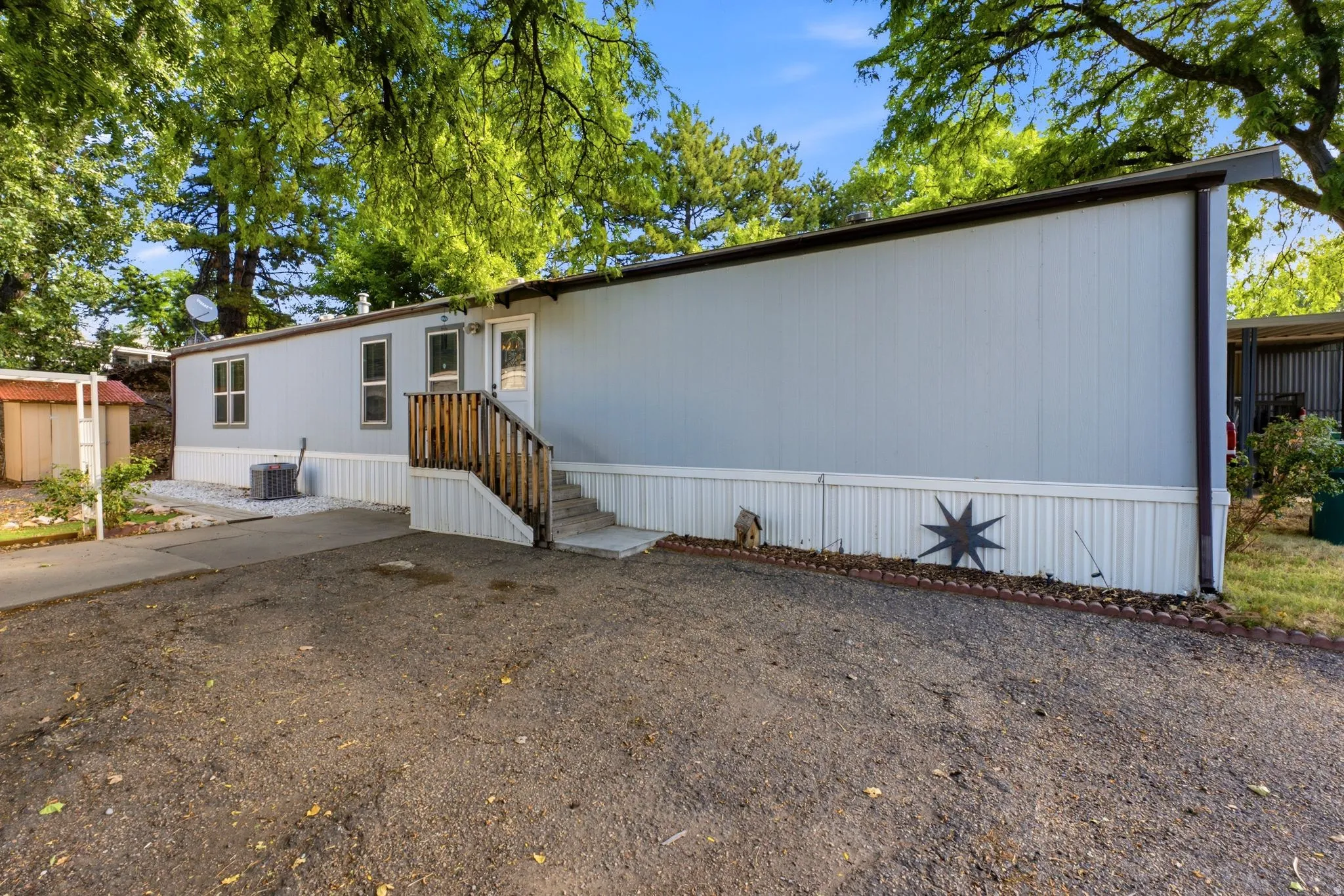 Manufactured home with light-colored siding and white skirting