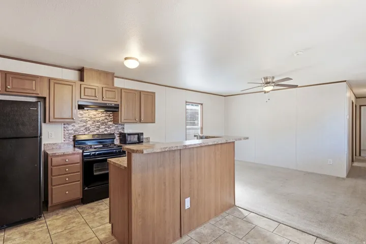 Kitchen featuring wood-finish cabinetry, tile flooring, and a breakfast bar