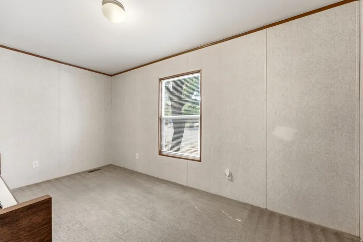Room with light-toned wall paneling and a carpeted floor