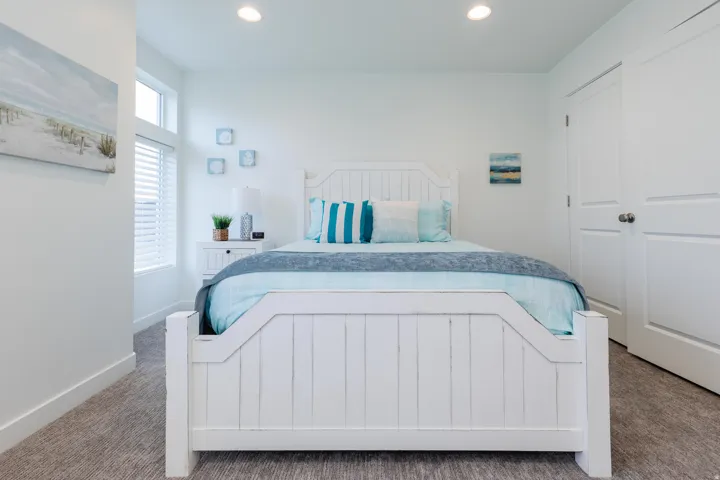Bedroom featuring a white framed window with blinds, recessed lighting, and neutral carpet flooring