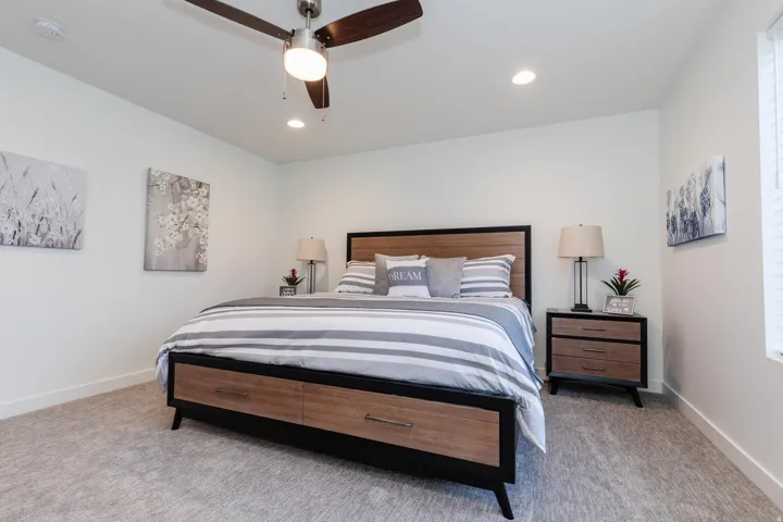 Spacious room featuring light-colored carpeting, recessed lighting, and a ceiling fan with integrated illumination
