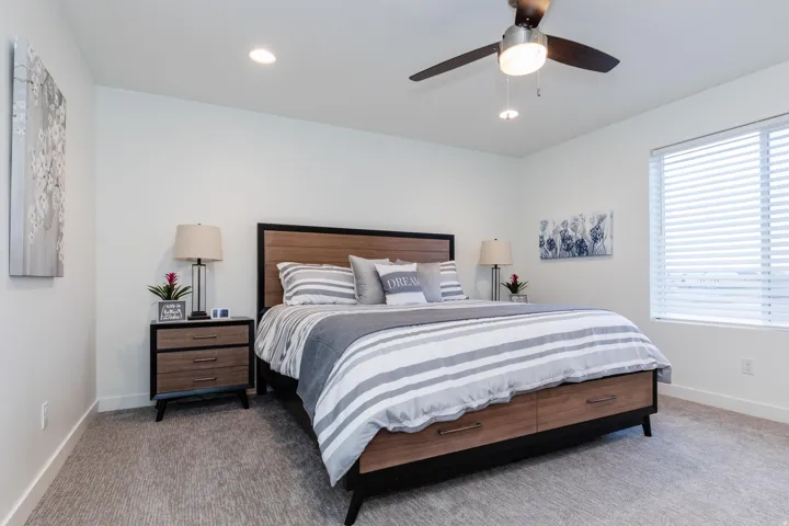 Carpeted room featuring a ceiling fan with integrated lighting, recessed lighting, and a large window with horizontal blinds