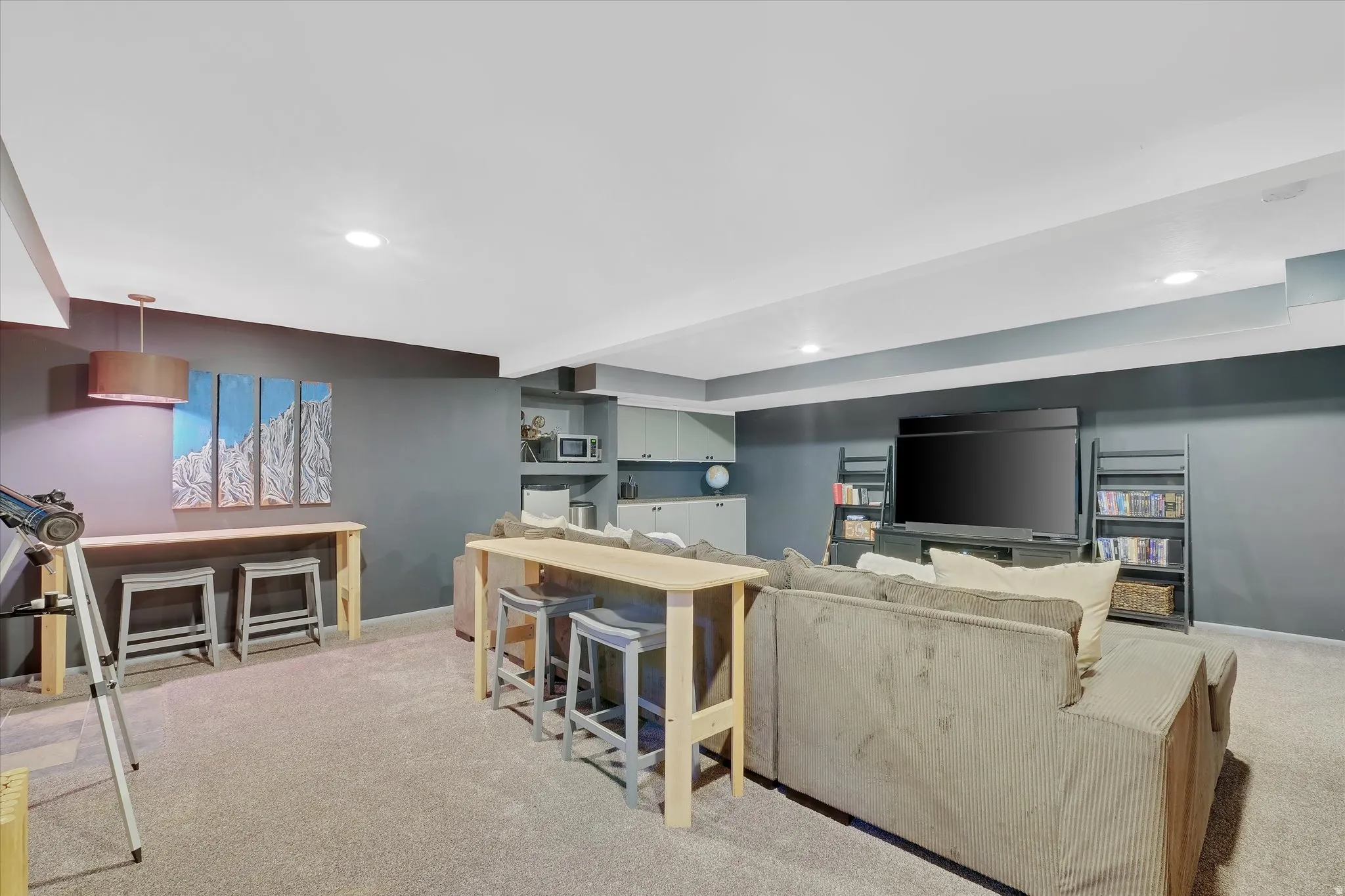 Finished lower level featuring recessed lighting, plush carpeting, a built-in media center, and a dedicated bar area with cabinetry and shelving