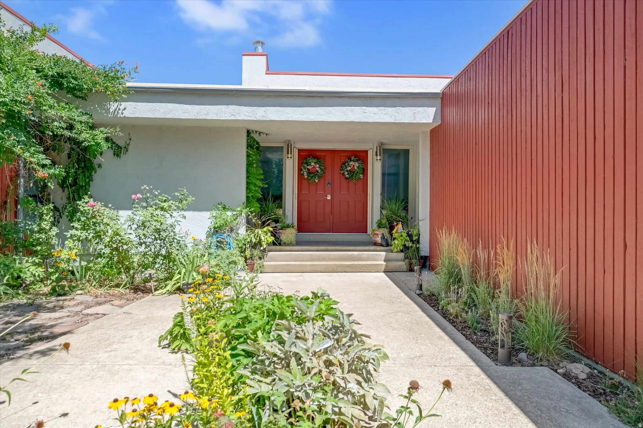 Modernist facade featuring a prominent red double-door entry
