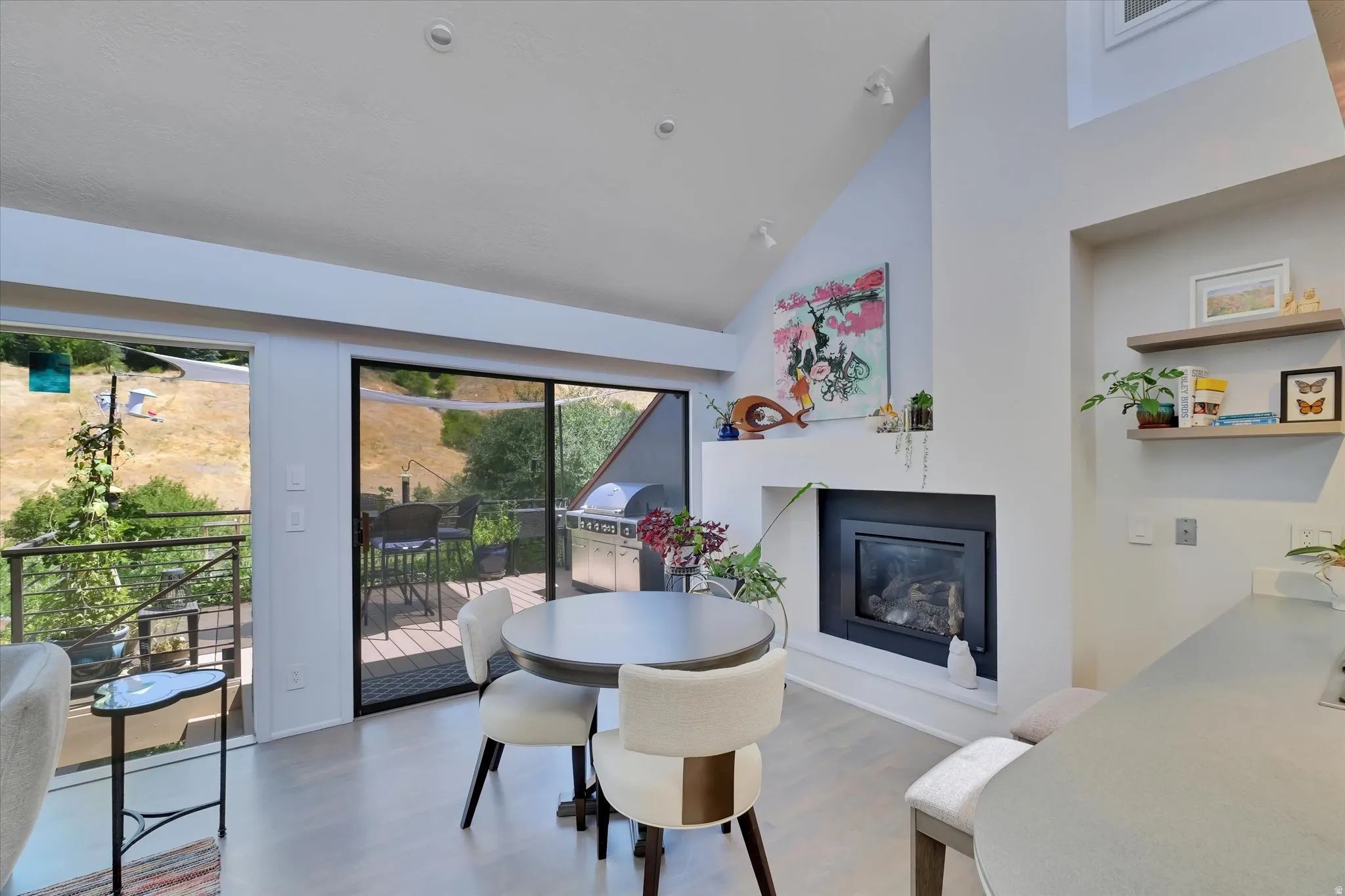 Vaulted ceiling interior featuring a built-in fireplace with a black surround and an exterior sliding glass door leading to a deck