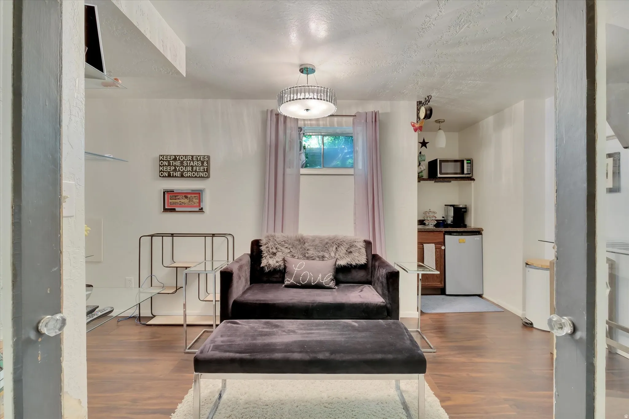Recreational room featuring wood-finish flooring, a built-in wet bar with cabinetry, and a ceiling-mounted light fixture