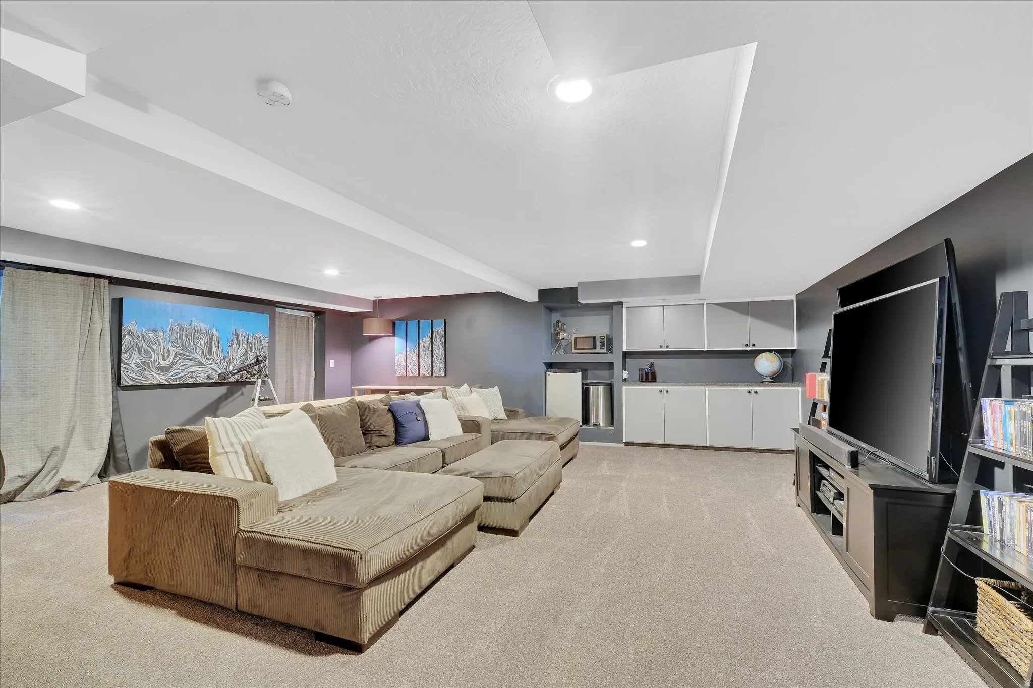 Carpeted recreation room featuring recessed lighting, a built-in entertainment center, and integrated cabinetry with shelving