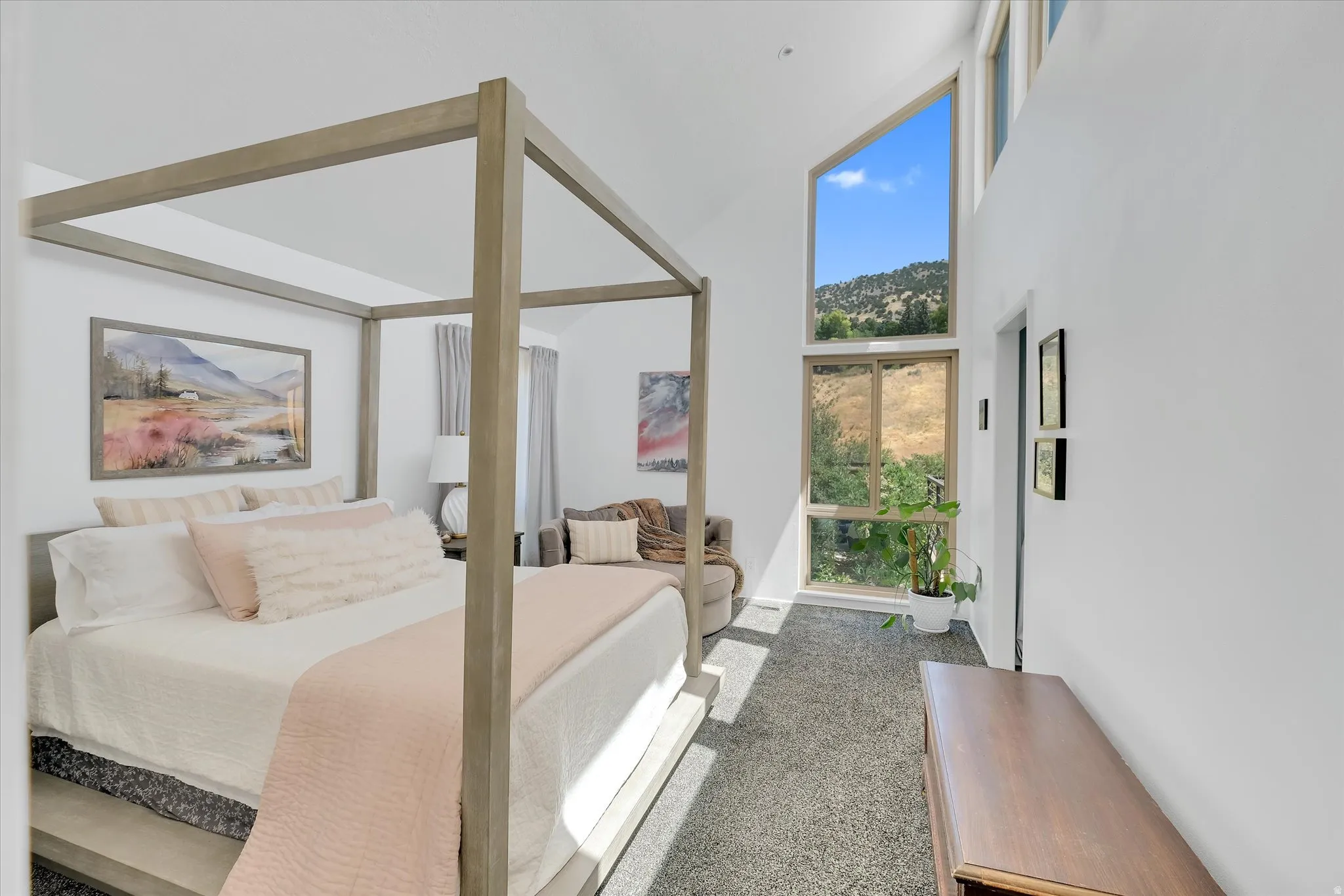 Room featuring a vaulted ceiling and a large, multi-paned window providing expansive outdoor views