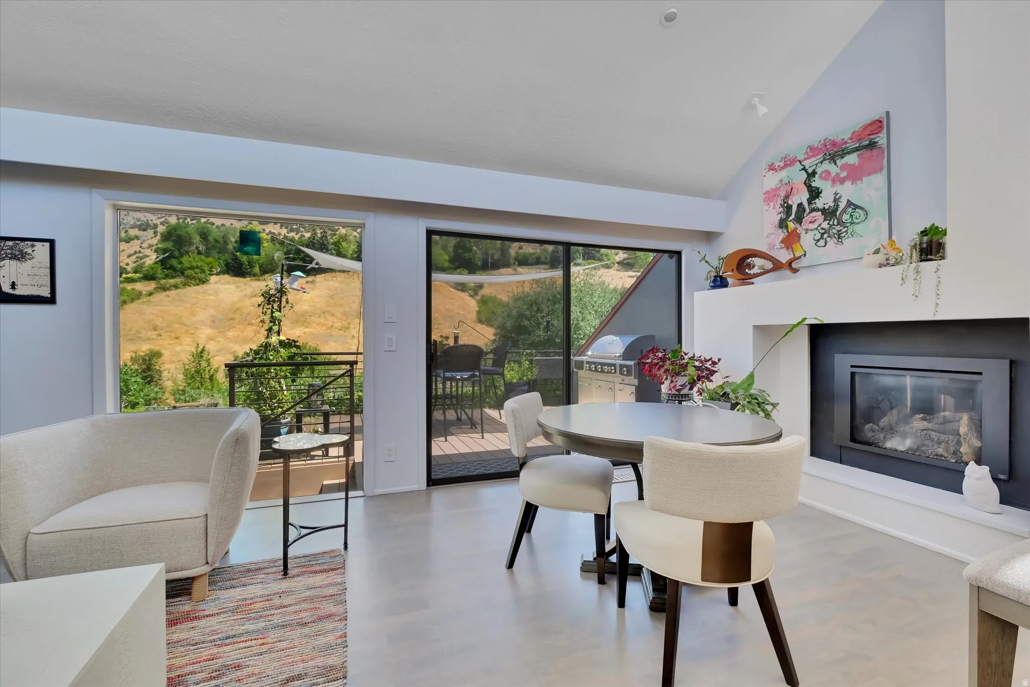 Bright living area featuring a vaulted ceiling and a built-in fireplace with a mantel