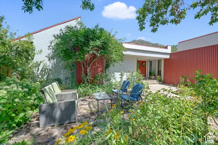 Stucco exterior featuring red accent siding and a contrasting orange entry door