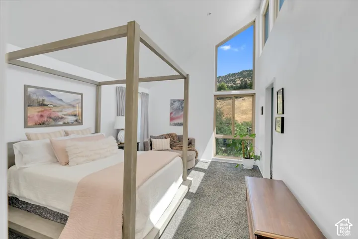 Room featuring a vaulted ceiling and a large, multi-paned window providing expansive outdoor views