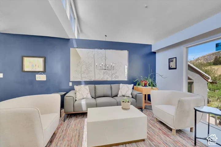 Living area featuring a vaulted ceiling with clerestory windows, a large picture window, and a decorative wall mirror