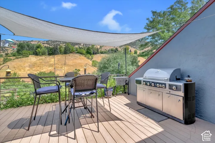 Spacious outdoor deck featuring wood-finish flooring and a partial shade canopy