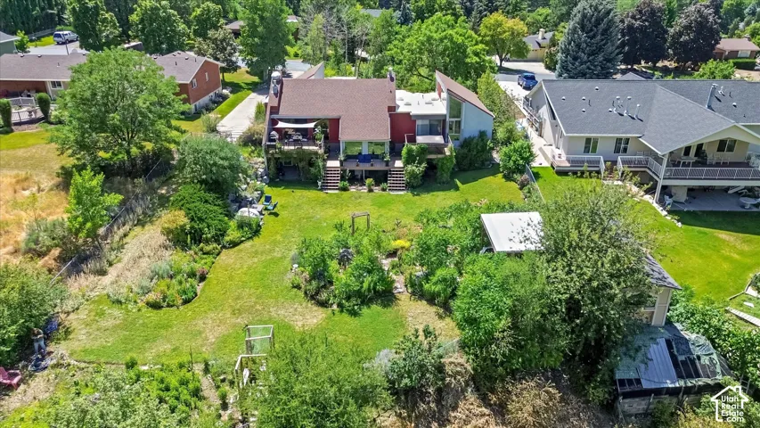 Multi-level residence featuring a red roof and exterior, multiple rear balconies, and an expansive lawn