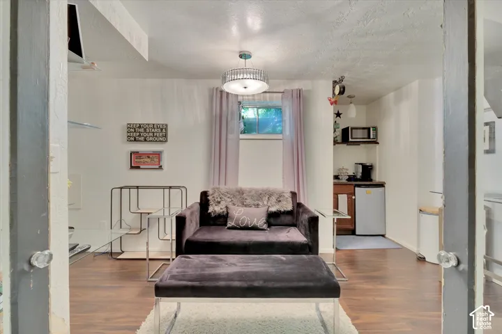 Recreational room featuring wood-finish flooring, a built-in wet bar with cabinetry, and a ceiling-mounted light fixture
