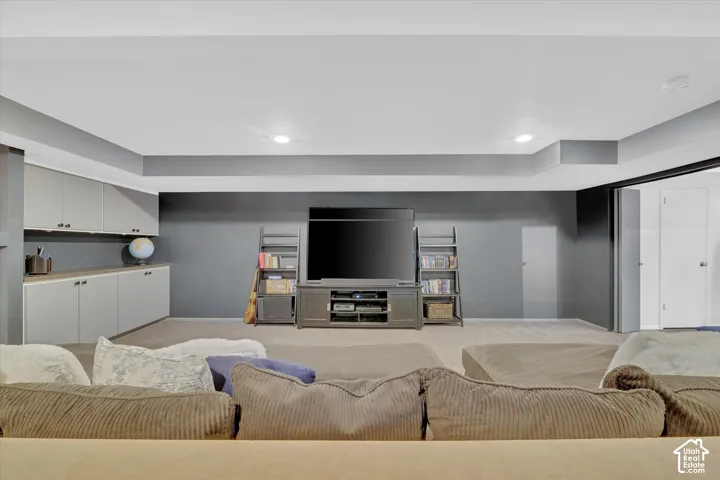 Spacious room featuring recessed lighting, a built-in media center, floor-to-ceiling shelving, and integrated cabinetry with a countertop