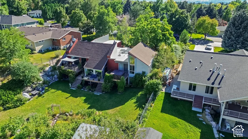 Multi-level property featuring a large backyard, extensive decking, and mature landscaping